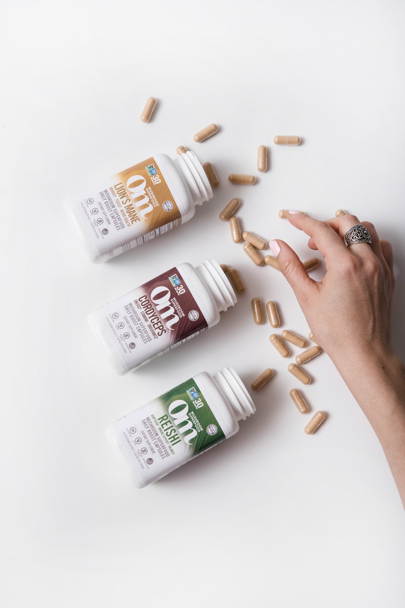 A hand reaching for mushroom capsules